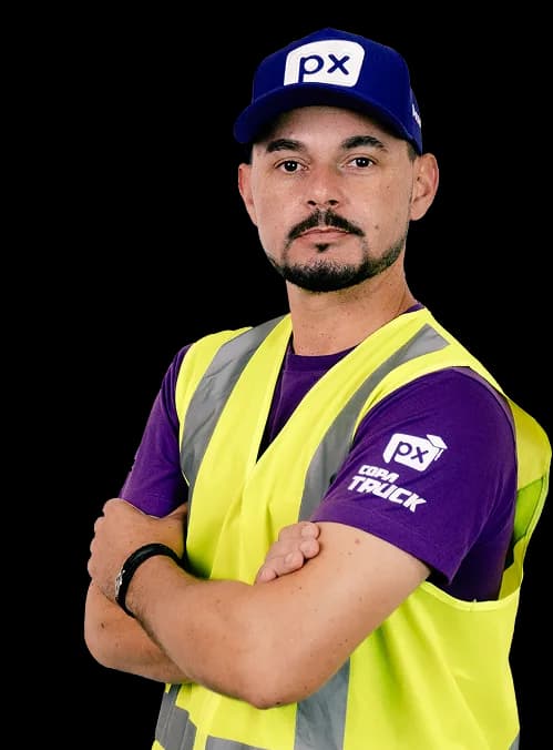 Instrutor da Academia PX de colete refletivo e boné, com os braços cruzados