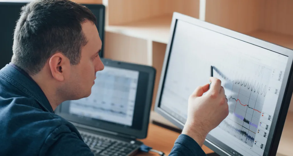 Homem analisando dados no computador.